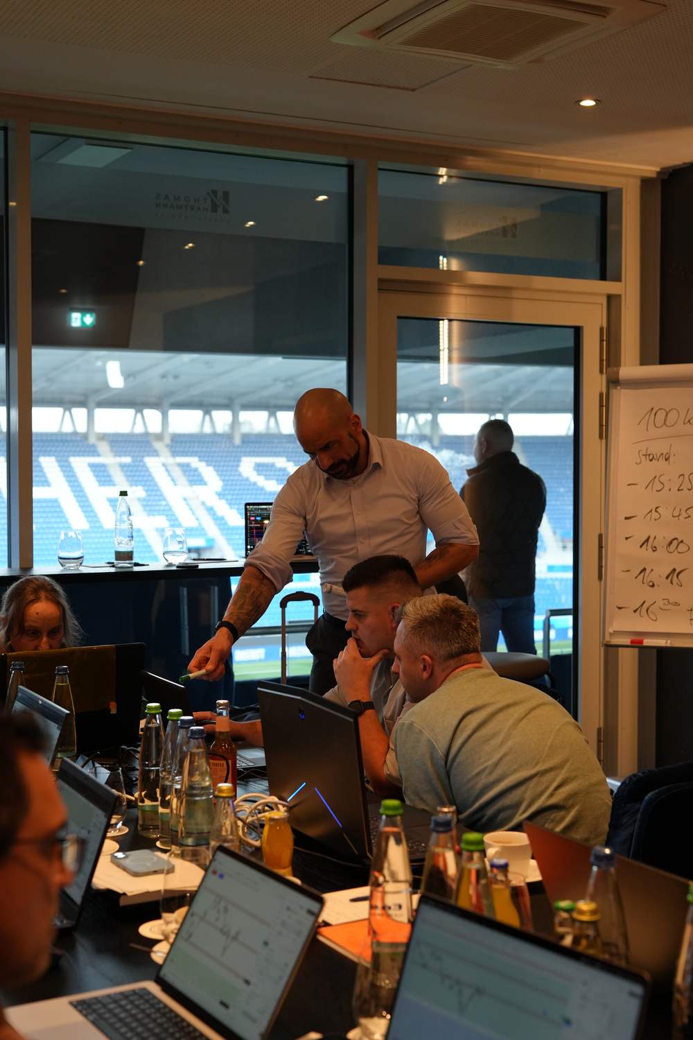 Thomas Hartmann beugt sich über den Laptop eines Teilnehmers und zeigt auf den Chart